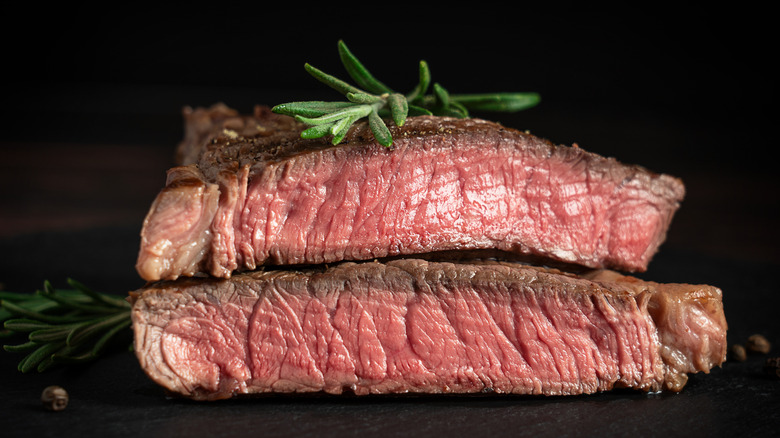 cut steak resting with rosemary on top