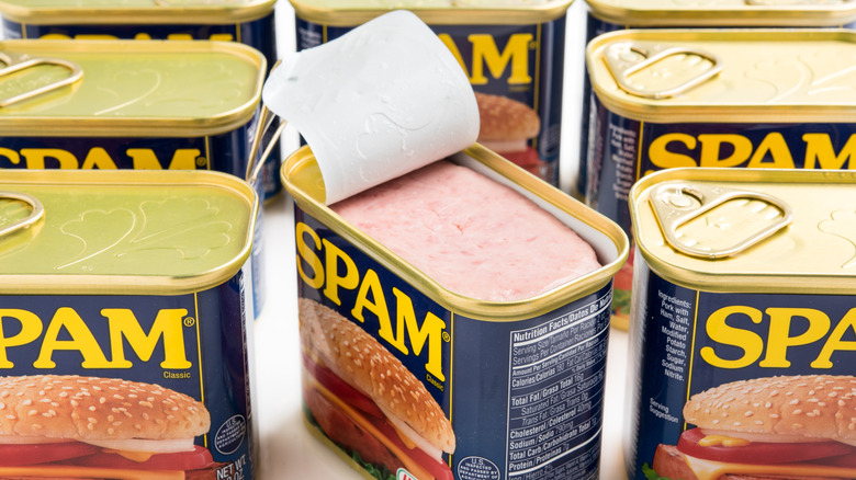 Cans of SPAM canned meat product with one opened lid 