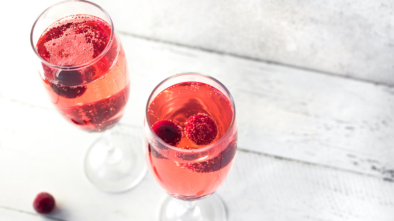 two glasses of kir royale with cranberries as a garnish