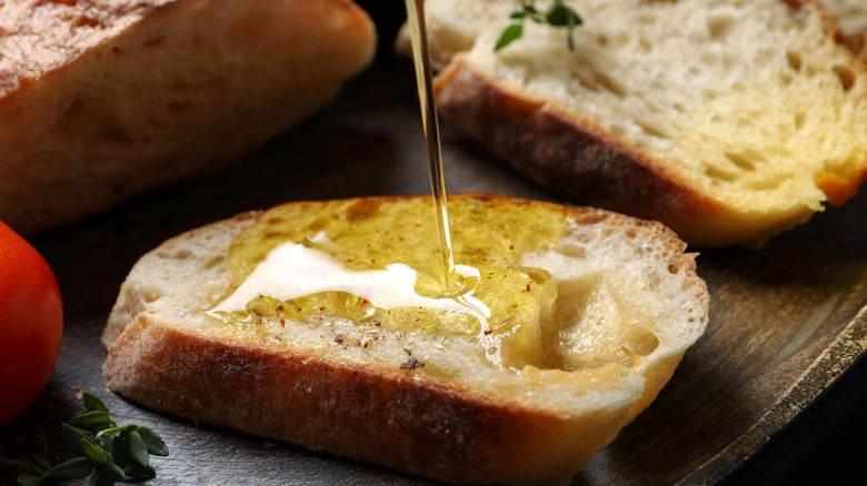 Pouring olive oil on bread slice