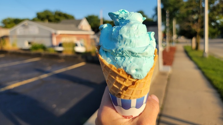 hand holding blue moon ice cream cone