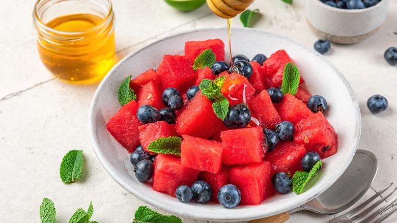 Bowl of watermelon and blueberries with drizzled honey