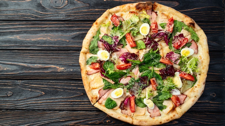 Chicken caesar salad pizza on a wooden table