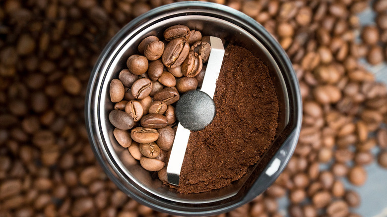 A grinder with coffee beans and powder