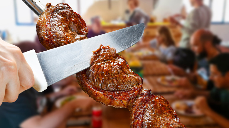 Picanha steak cut off a skewer at a Brazilian steakhouse