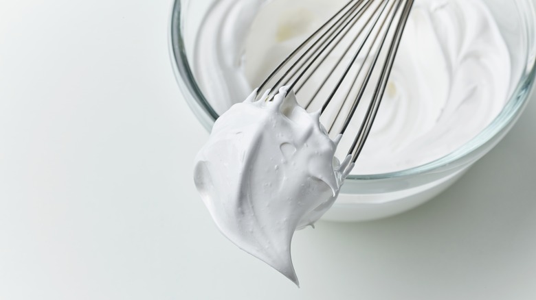 Close-up, whisking an egg white with small metal whisk