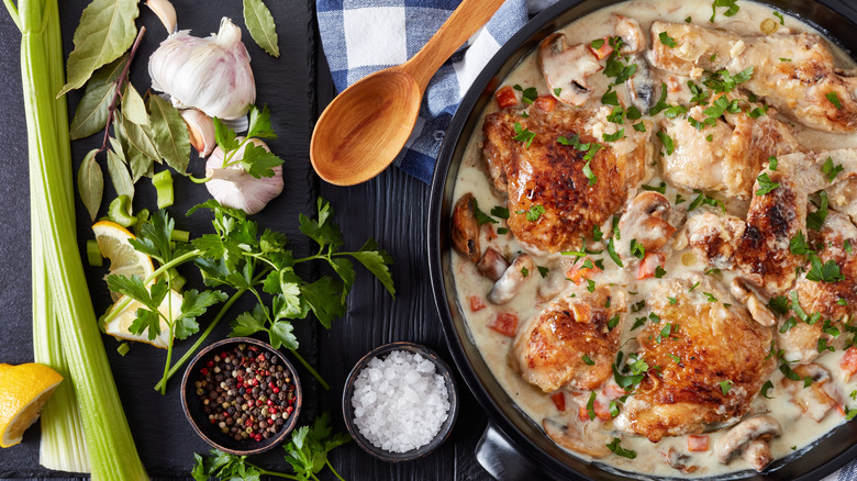 chicken fricassee in dutch oven next to aromatics