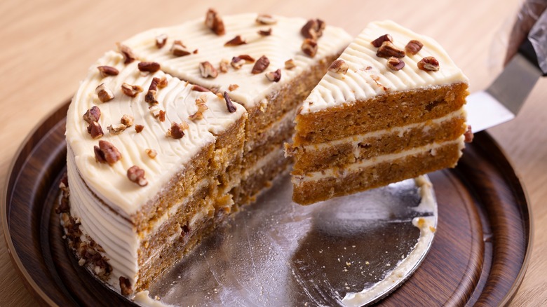 Slice of carrot cake with cream cheese frosting and nuts