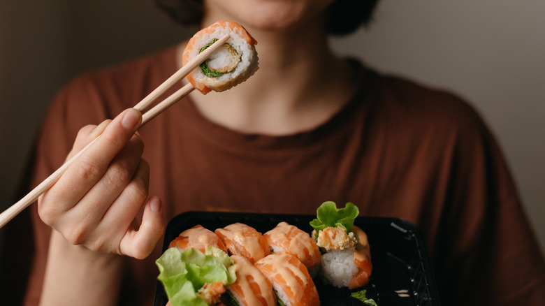 person eating salmon sushi