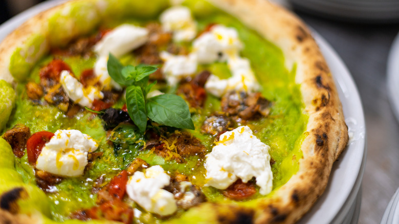 Pizza with green sauce and burrata