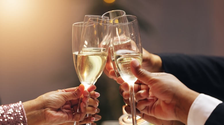 Hands toasting five glasses of Champagne