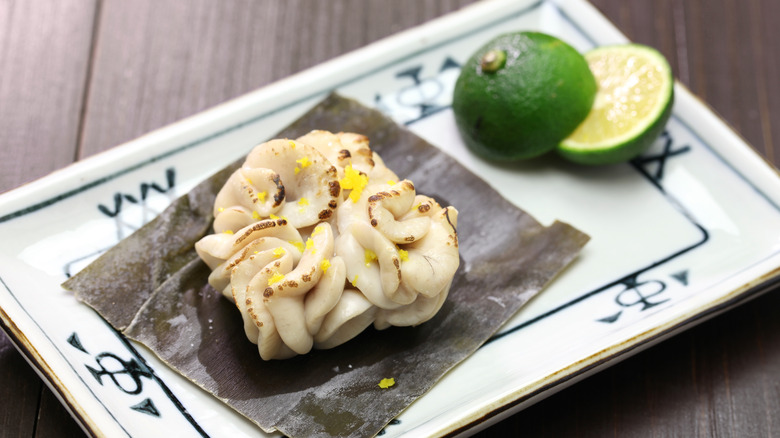 Grilled cod milt on seaweed with sliced lime