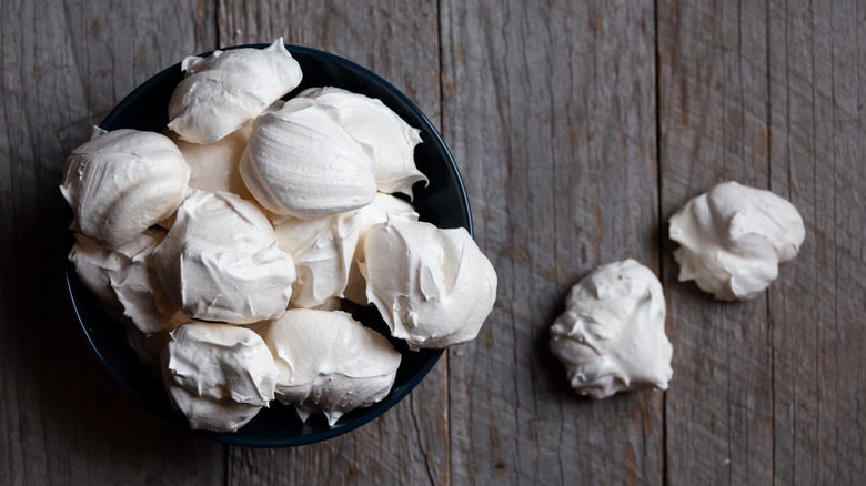 Bowl of meringues on a wooden table