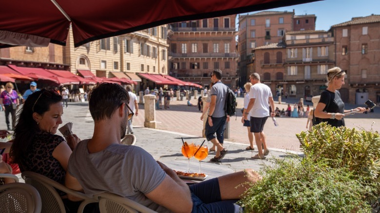 People at a restaurant overlooking a square in Italy