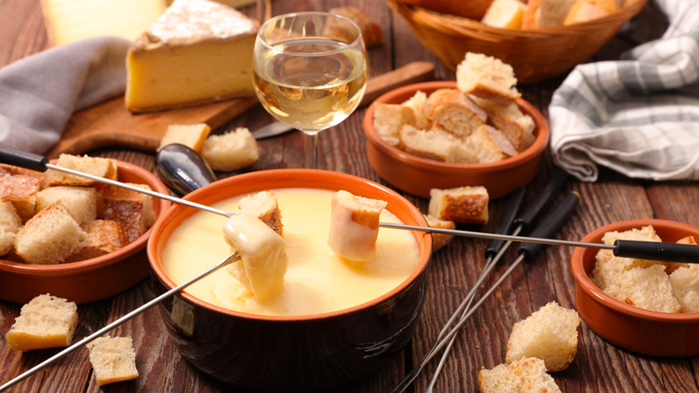 Cubes of bread being dipped into fondue at the table