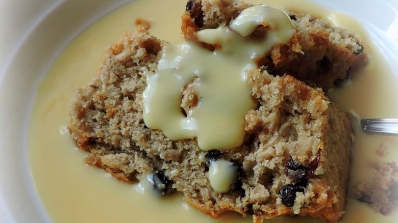 British spotted dick pudding with runny custard on a plate
