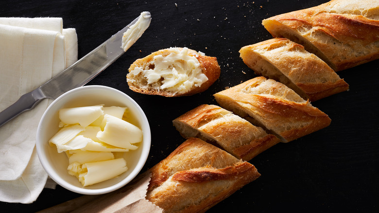 sliced baguette with knife and butter
