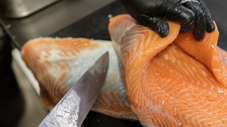 Chef skinning salmon