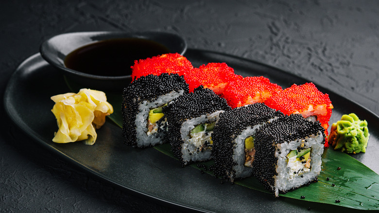 Pieces of sushi covered in black and orange tobiko