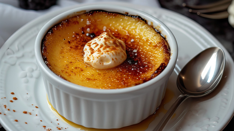 pot of creme bruleé on white plate with spoon