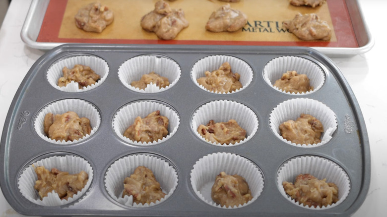 A host of pralines sit in a muffin pan and on a silicone baking tray