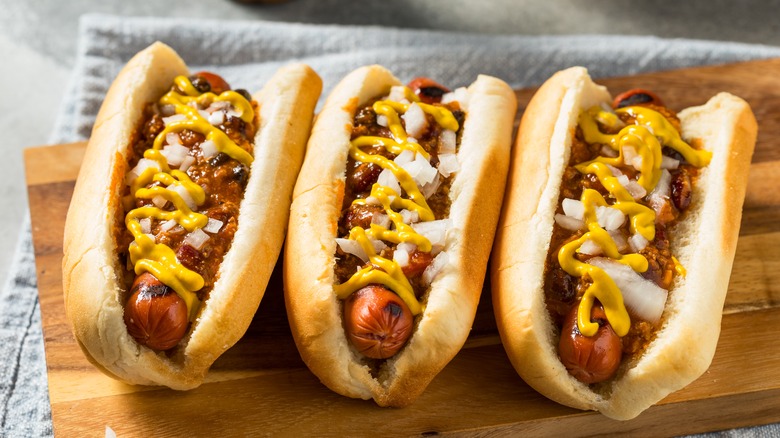 Three Coney Island hot dogs with chili onions mustard