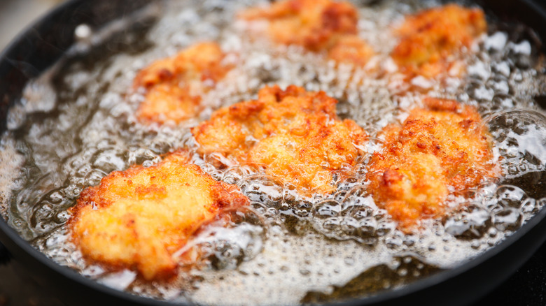 Frying chicken in a pan at home