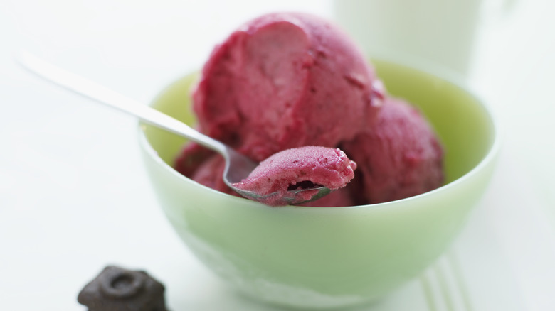 Magenta-colored water ice in a bowl with silver spoon