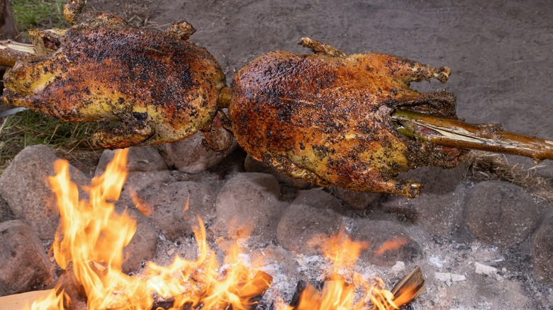 Fowl roasting over wood fire