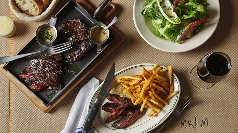 Steak frites and green salad on table