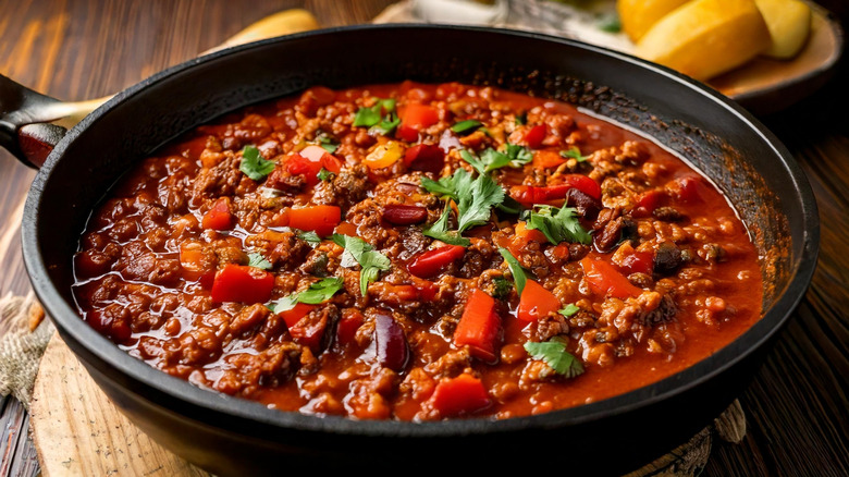 A large black bowl sits filled with chili