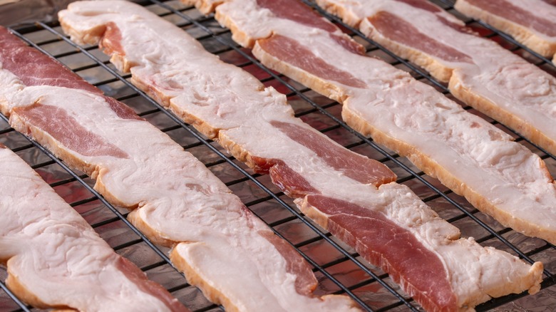 Uncooked bacon on wire rack