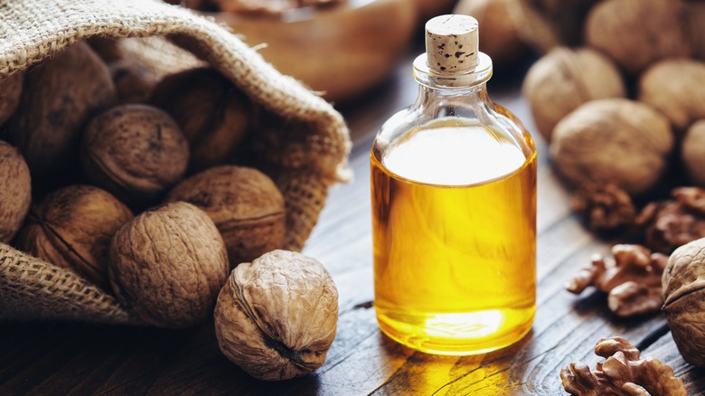 Bottle of oil next to walnuts
