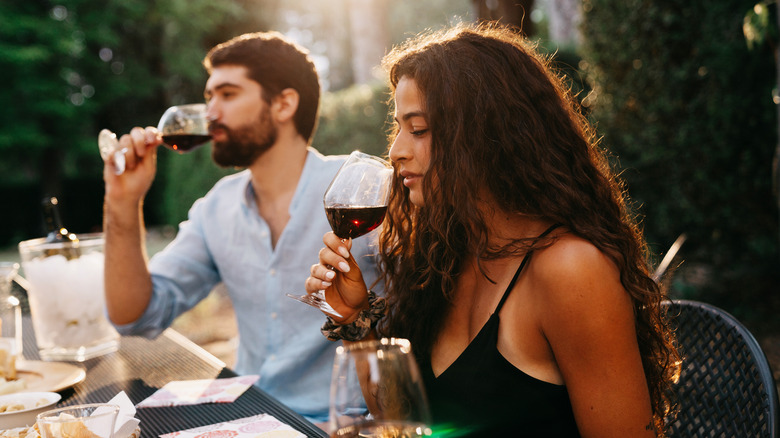 couple tasting red wine outdoors