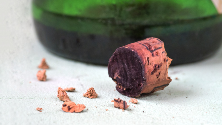 Broken cork with small pieces and glass bottle