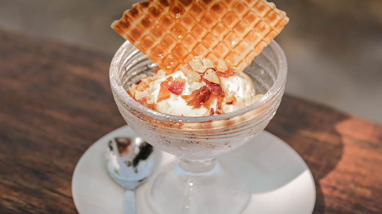 Vanilla ce cream with bacon pieces and waffle cone triangle