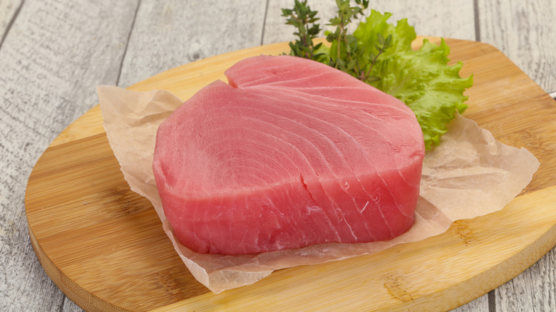 A rosy ahi tuna steak on cutting board