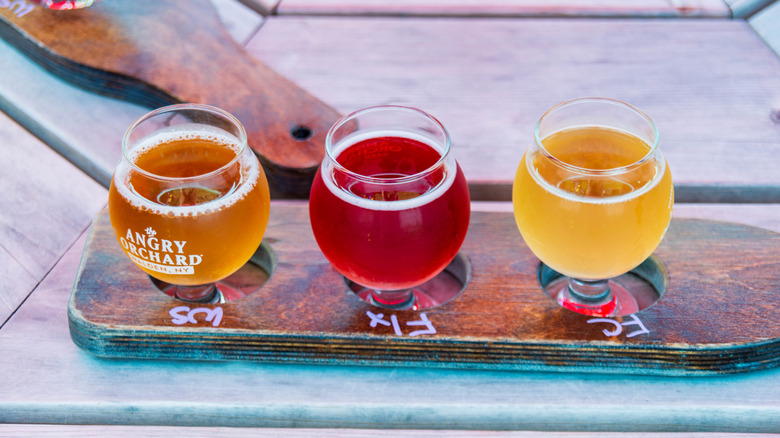 A flight of Angry Orchard hard cider sits on a wooden table