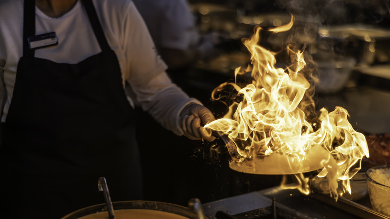 chef flambeing in a pan