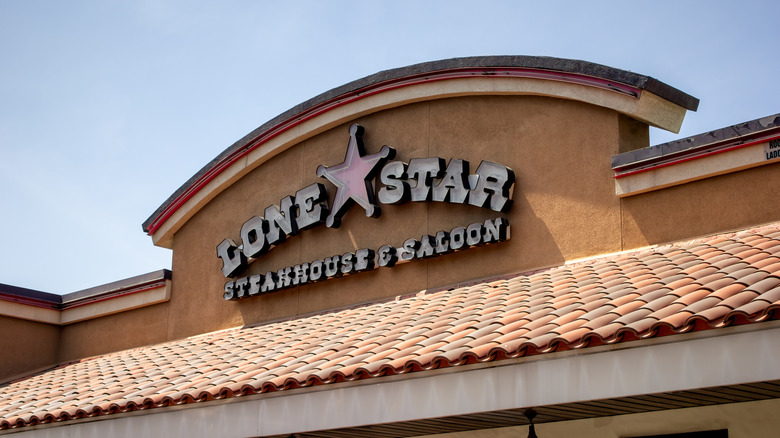 Exterior shot of a Lone Star Steakhouse and saloon sign that is unlit during the daytime