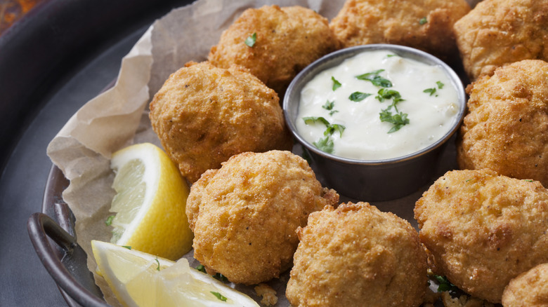 Plate of hushpuppies with dip and lemon slices