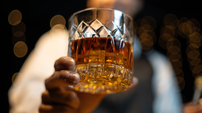 Bartender holding glass of whiskey