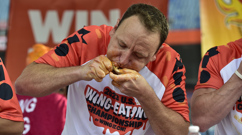 joey chestnut eating a chicken wing