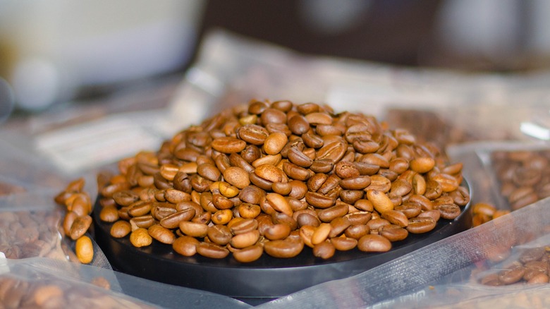 Pile of light roasted coffee beans on a black surface