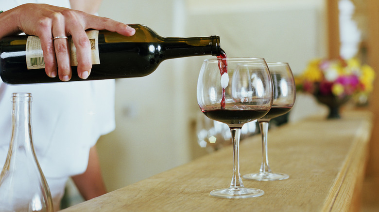 Person pouring wine into glass