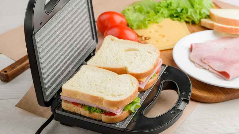 A sandwich before being cooked in a panini press.