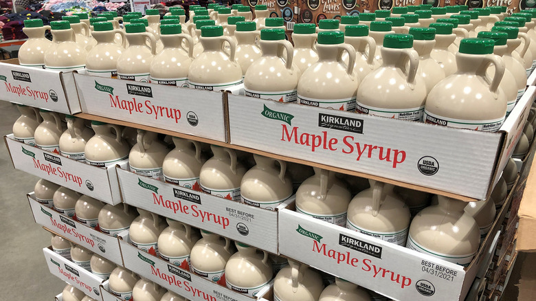 Bottles of Kirkland Signature maple syrup in stacked cardboard boxes