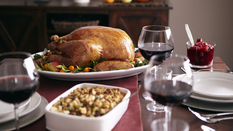 Thanksgiving table with dressing, turkey, and wine glasses