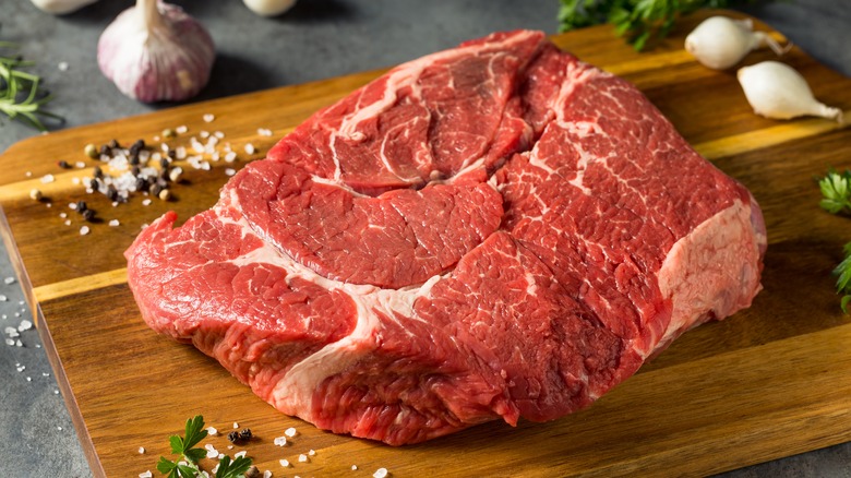 cut of raw chuck roast on cutting board