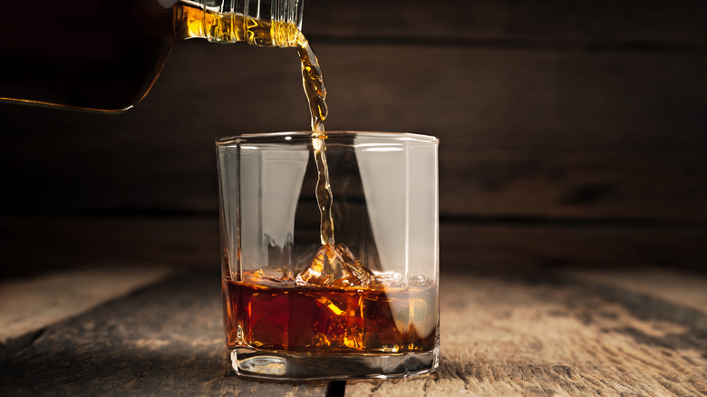 Bottle of rum poured into glass